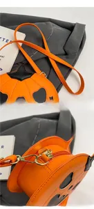 Detail of smooth shoulder strap and gold zipper hardware on orange pumpkin bag