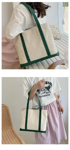Detail view of large canvas tote bag with cream body and dark green contrast handles