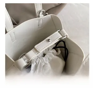 Macro shot of white bucket bag featuring premium pebble leather and satin drawstring liner