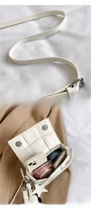 Detail of white woven crossbody bag with magnetic closure and interior storage