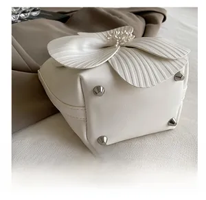Close-up of white 3D flower bag base featuring four silver protective metal studs