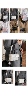 Detail of woven texture crossbody bag with metal chain strap and decorative charms