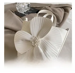 Detail showing white PU leather handbag with 3D floral decoration and wrinkled texture