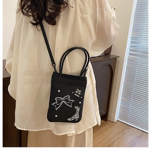 Detail of black mini crossbody bag with chic sequin patches and pearl decorations