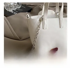 Detailed macro of white PU leather tote with silver metal chain strap and fine texture