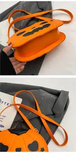 Detailed close-up of orange PU leather pumpkin crossbody bag with black face appliqué