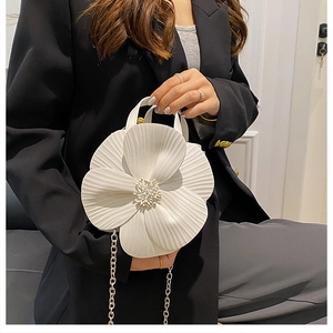 Detailed macro view of a white flower-shaped handbag with textured petals and beaded center