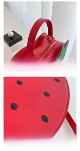 Close-up of strawberry handbag showing reinforced handle and meticulous stitching