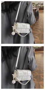 Detail of white woven leather crossbody bag with star pendant and debossed logo texture