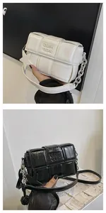 Close-up of luxury woven puffy square crossbody bag with silver chain and star charm