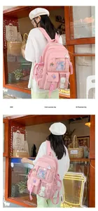 Detailed view of a pink nylon school backpack featuring multiple pockets and cute plush toys
