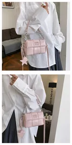 Detail of light pink woven crossbody bag with star charm and metallic chain strap