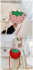 Detail of red and pink strawberry-shaped PU leather crossbody bags with leaf accents