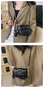 Close-up of black woven crossbody bag with COIH ZDN logo and elegant metal chain strap