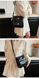 Detail of black glossy faux leather messenger bag featuring double silver metal turn locks