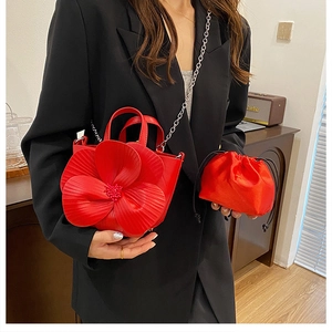 Detail of red floral petal bucket bag with satin drawstring inner pouch and metal chain