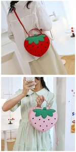 Detail of red and pink strawberry-shaped handbags with green leaf accents and crossbody straps