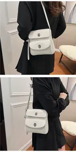 Detailed view of white double-pocket shoulder bag with silver metallic twist locks