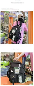 Close-up of black school backpack featuring transparent pocket and cute plush accessories