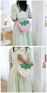 Close-up of strawberry-shaped shoulder bag with glitter leaf detail and polka dots