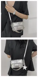 Detail of silver woven crossbody bag featuring metallic texture and star pendant