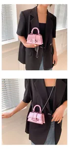 Detail of laser pink metallic mini handbag showing pearly finish and bead chain strap