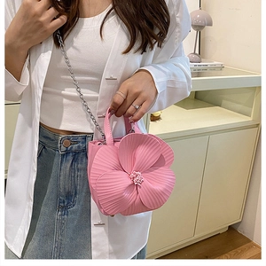 Detail of pink floral shaped PU handbag with silver chain strap and beaded flower center