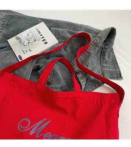 Détail du sac cabas en toile rouge avec lettrage Mean et bandoulière confortable