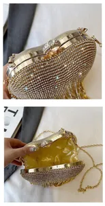 Détails de la pochette dorée en strass avec pompon, fermoir anneau et doublure en soie