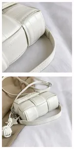 Detail of white woven square bag featuring leather strap and star-shaped pendant