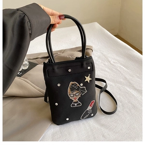 Detail of black nylon mini bag with rhinestone female head and star patchwork