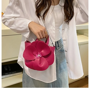 Detailed view of 3D rose petal handbag in vibrant magenta with silver chain strap