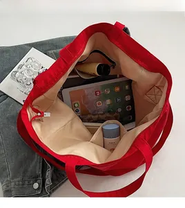 Vue de dessus montrant l'intérieur spacieux avec poches de ce grand sac fourre-tout rouge