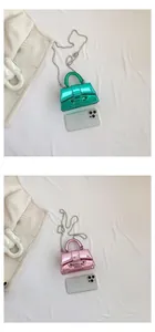 Micro mini metallic crossbody bags with silver chains compared to a smartphone size