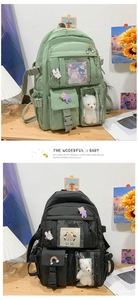 Detail of green and black school backpacks with transparent windows and cute plush charms