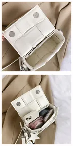 Macro view of woven leather shoulder bag with magnetic clasp and internal capacity detail