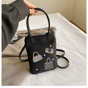 Detail of black nylon mini tote bag with sparkling rhinestone purse patterns and crossbody strap