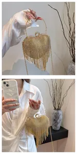 Detail of heart-shaped clutch with champagne rhinestones and fringe tassels on golden frame