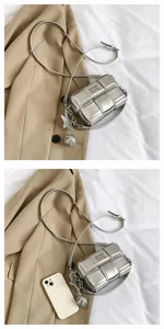 Macro shot of silver woven mini crossbody bag with star pendant and sleek metal ball detail