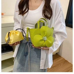 Detail of green petal bag with yellow satin pouch and chic metal chain strap