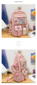 Detail of pink multi-pocket student backpack with cute decorative pins and plush bear pendant