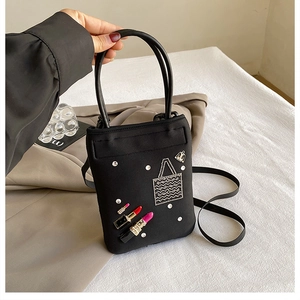 Detail of black nylon phone bag with sequin lipstick embroidery and metal charm detail
