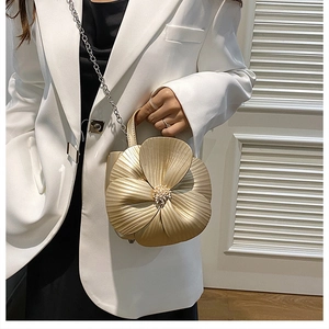 Close-up of golden petal handbag with detailed floral texture and crystal center