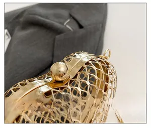 Close-up of golden hollow honeycomb evening bag featuring a spherical metal clasp