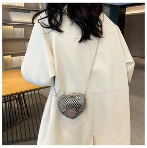 Detail of silver heart-shaped metal mesh bag with sleek chain strap and ball clasp