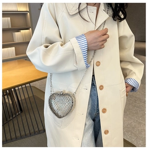Detail of silver heart-shaped metal mesh crossbody bag with delicate chain strap