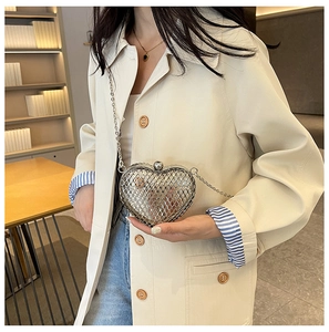 Detail shot of a silver heart-shaped metal mesh crossbody bag with a delicate chain strap