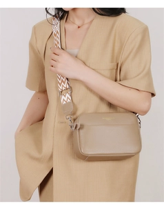 Detail of khaki leather crossbody camera bag with wide geometric patterned strap