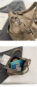 Detail view showing sturdy metal hook and large interior space of the khaki suede Boston bag