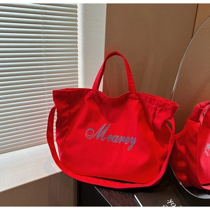 Détail du grand sac cabas en toile rouge avec logo Mearey et bandoulière réglable
